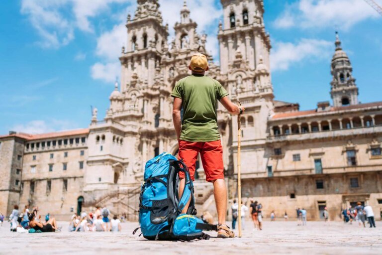 Man-walking-the-camino-standing-in-front-of-main-square-Obradeiro-Solovyova-iStock.jpg